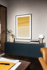 Ceramics XIII — Amber. Ochre across the top breaking into long horizontal drifts and thinning to near-white at the bottom. Hung on a wall in a room. Shown framed. Frames and mounts are not included.
